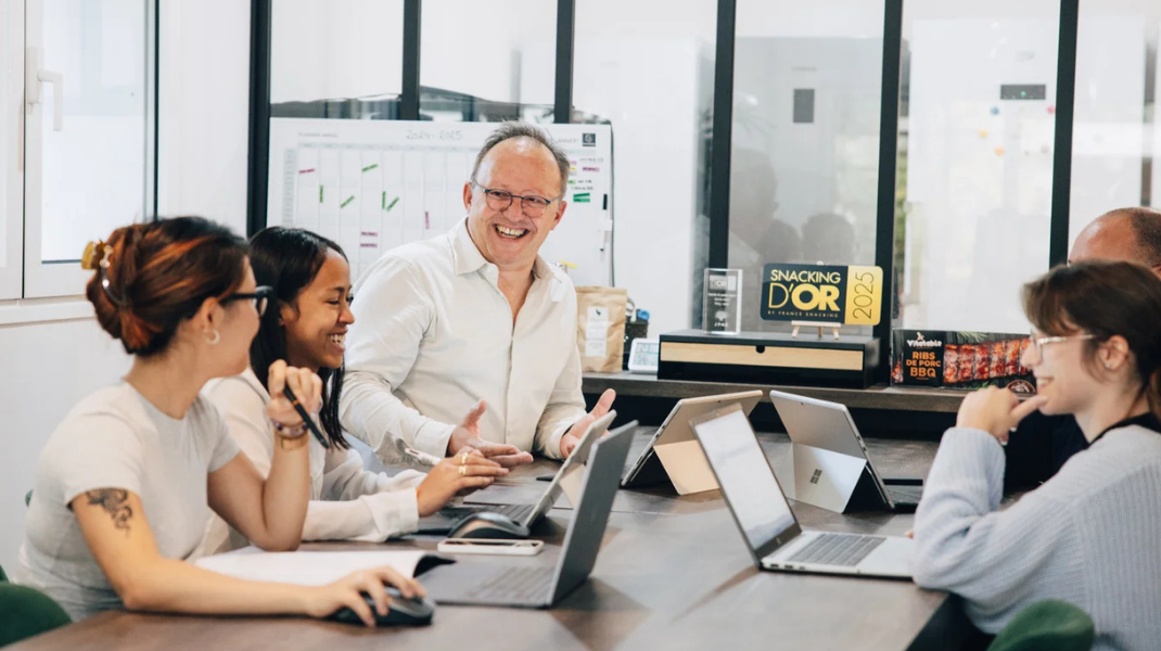 Équipe de JPAC en réunion, tout le monde est souriant